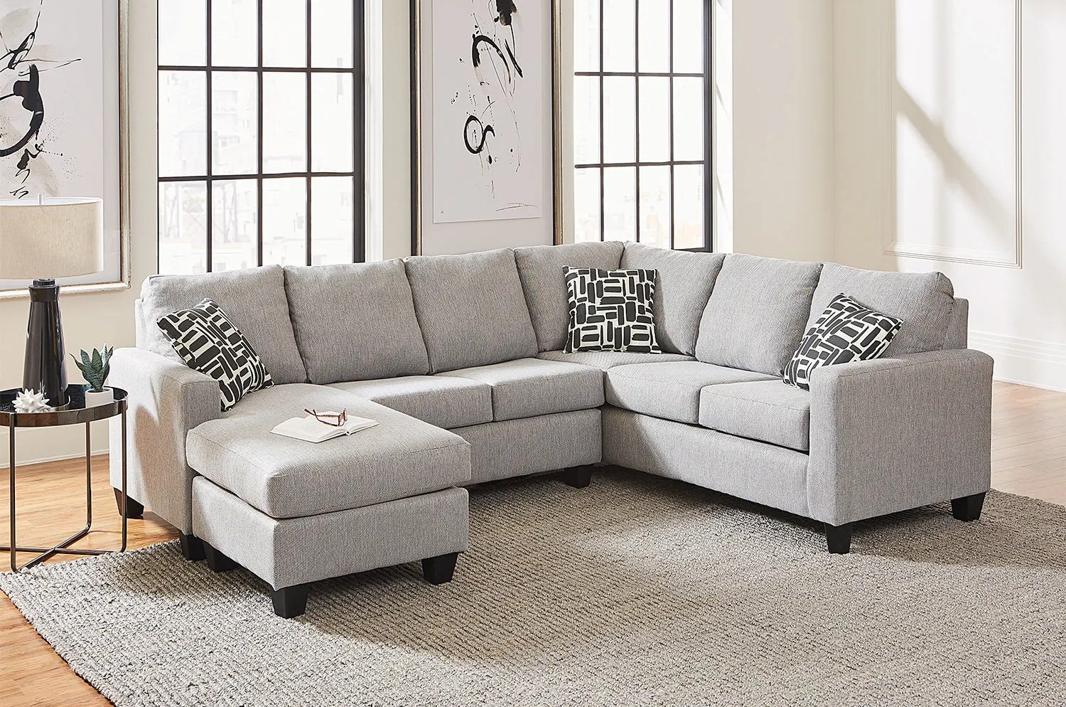 Living room decor with a sectional sofa with a chaise lounge in a light gray fabric color.